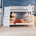 White wooden kids bunk bed with built-in storage stairs in a children's bedroom, rust and beige bedding, throw pillows and wall lamps against blue patterned wallpaper