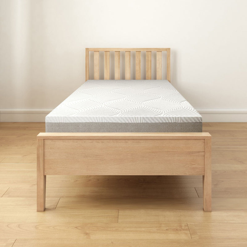 Wooden bed frame with comfortable mattress in minimalist bedroom setting.