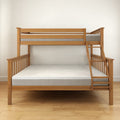Wooden bunk bed with ladder and mattresses on hardwood floor.