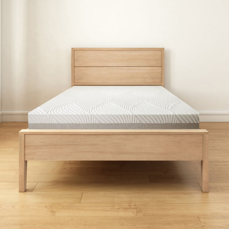 Modern wooden bed frame with a comfortable mattress in a minimalist bedroom setting.