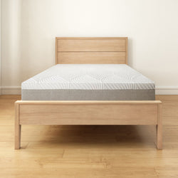 Modern wooden bed frame with comfortable mattress in minimalistic bedroom setting.