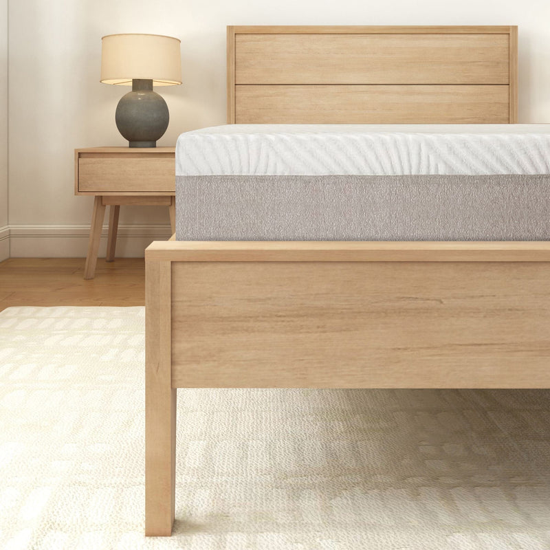 Modern wooden bed frame in a cozy bedroom with a nightstand, lamp, and comfortable mattress.