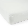 Soft white mattress topper on a bed, enhancing comfort and support for a restful sleep.