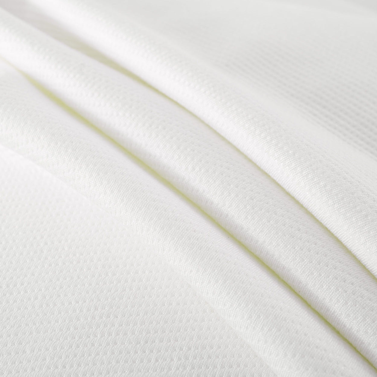 White textured fabric close-up, highlighting soft and smooth material ideal for clothing.