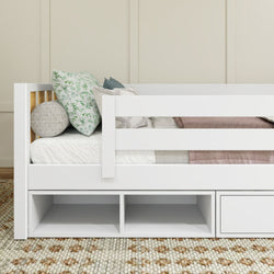 White kids' bed with built-in storage, decorative pillows, and cozy bedding on a textured rug.