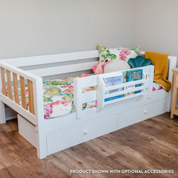 White daybed with storage drawers and floral bedding in a cozy room.
