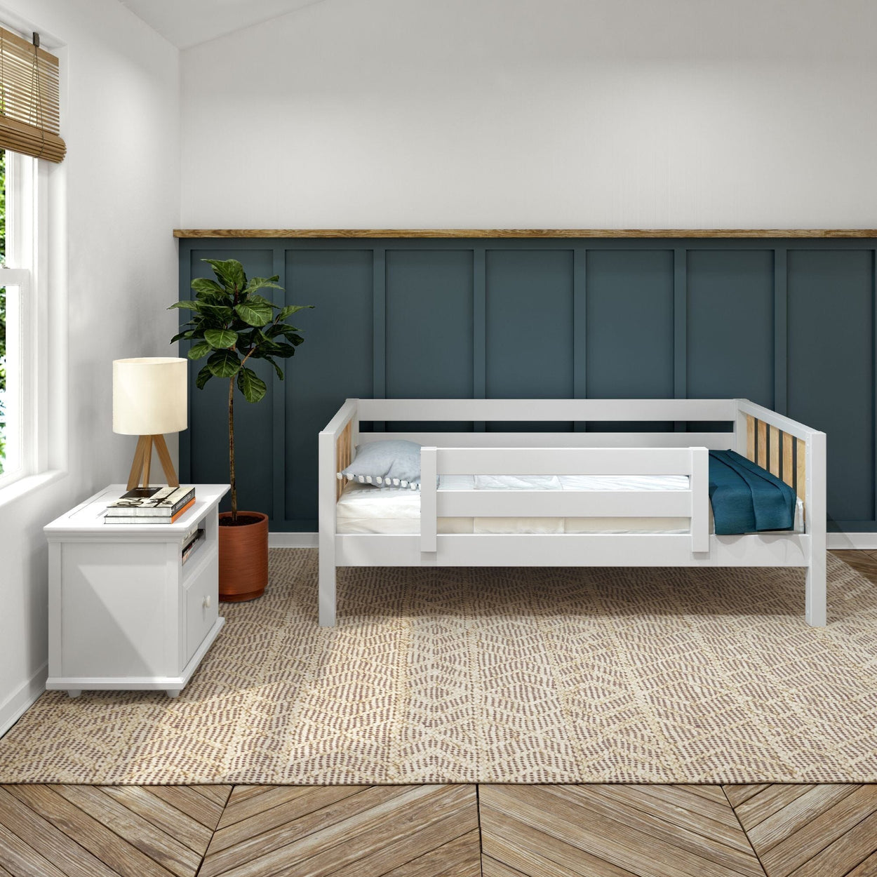Modern nursery kids bedroom with white toddler bed, navy board-and-batten wainscoting, bedside table and lamp, potted fiddle-leaf fig and textured rug