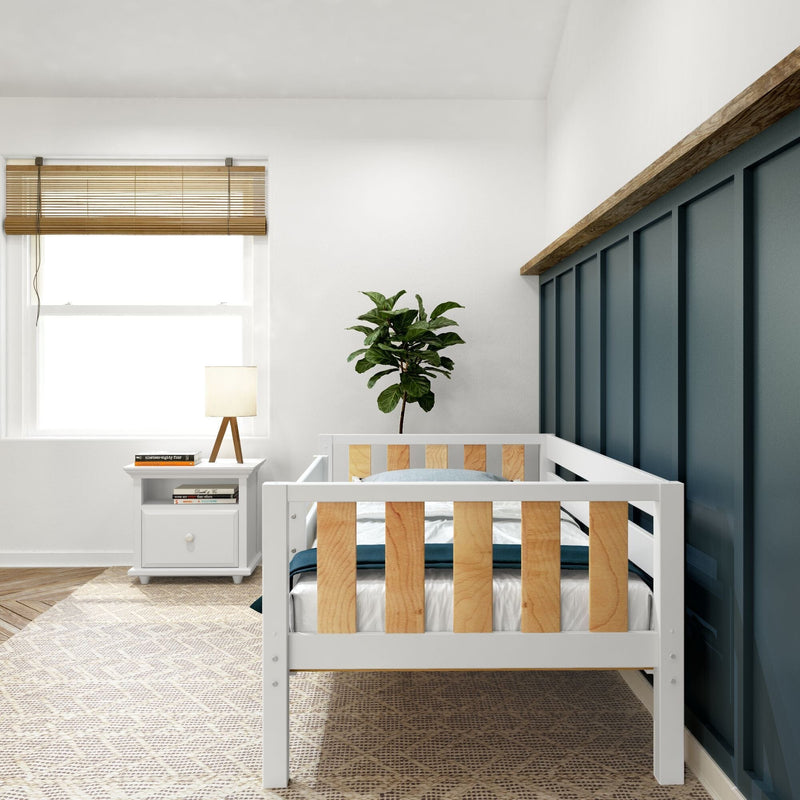Modern minimalist nursery with white crib featuring wooden slats, navy blue paneled accent wall, window with bamboo blinds, white nightstand with lamp and fiddle leaf fig plant