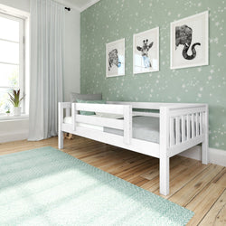 Modern nursery with white wooden crib/toddler bed, mint-green star wallpaper, framed zebra/giraffe/elephant prints, teal rug, sheer curtains and potted plant
