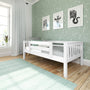 Nursery with white wooden toddler bed, mint star wallpaper, framed zebra giraffe elephant prints, mint rug.