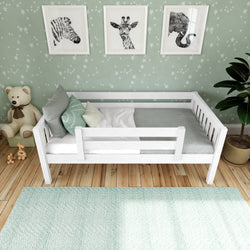 White wooden toddler bed with safety rail in a mint-themed nursery, star-pattern wallpaper, animal wall art, plush teddy bear, hardwood floor and mint area rug