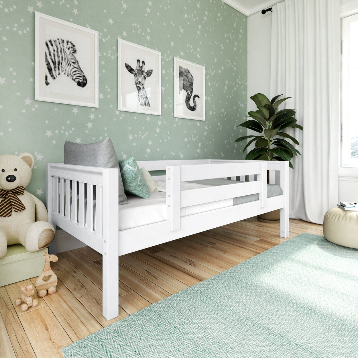 White wooden toddler bed in mint green star-patterned nursery with framed animal wall art, plush teddy, wooden toys, indoor plant and textured area rug