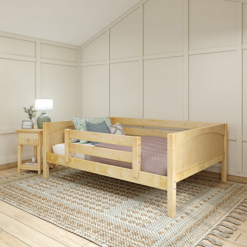 Natural wood twin bed in cozy kids bedroom with board-and-batten accent wall, woven boho rug, bedside table, lamp and soft pillows
