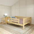Natural wood toddler bed in a modern nursery with pastel throw pillows, bedside lamp on a nightstand, textured woven rug and beige paneled walls