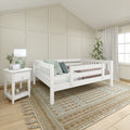 Modern neutral nursery with white toddler bed, board-and-batten accent wall, woven textured rug, white nightstand and lamp, potted plant and sheer curtains